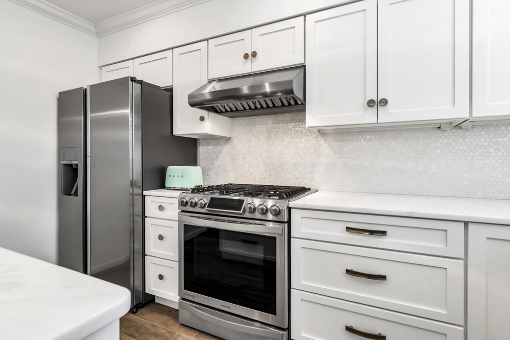 6 Summer Street, Unit D Manchester, MA 01944 - Photo 14 of 31 a kitchen with stainless steel appliances granite countertop a stove a refrigerator and a white cabinets
