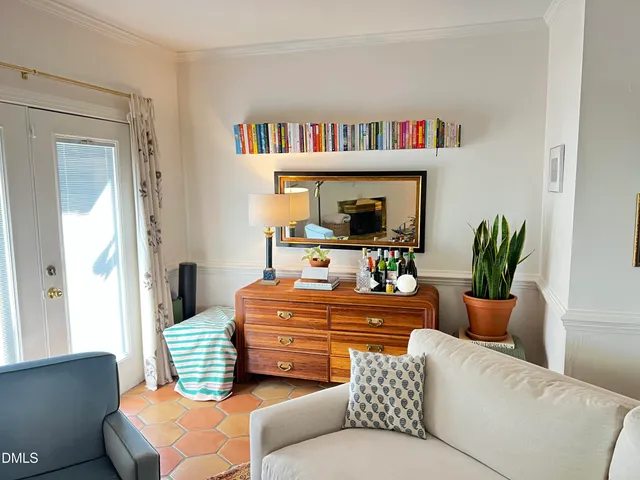 a living room with furniture a bookshelf and a potted plant