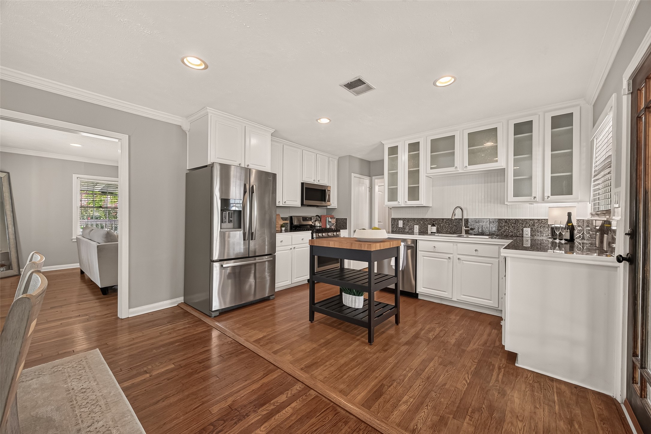 2019 Gostick Street Houston, TX 77008 - Photo 16 of 36 a kitchen with stainless steel appliances a refrigerator a stove a sink dishwasher and a dining table with wooden floor