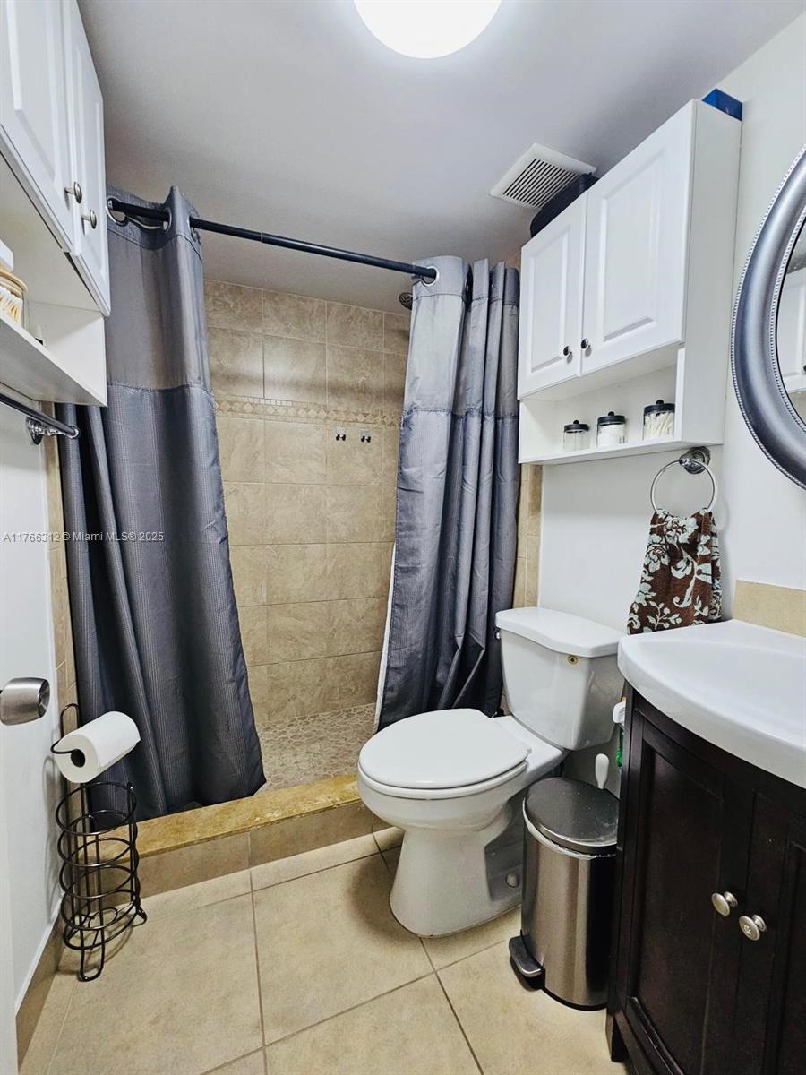 8788 Southwest 12th Street, Unit 103 Miami, FL 33174 - Photo 7 of 15 a bathroom with a toilet a sink and a shower