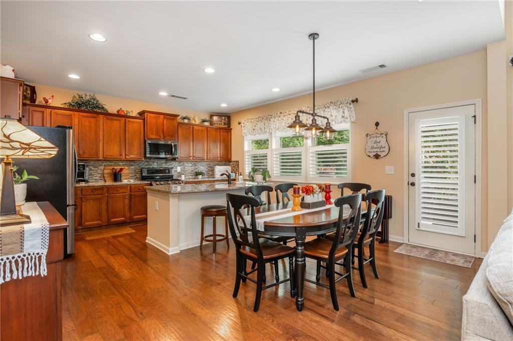 407 Ward Farm Drive Powder Springs, GA 30127 - Photo 19 of 67 a kitchen with stainless steel appliances kitchen island granite countertop a table chairs and a refrigerator