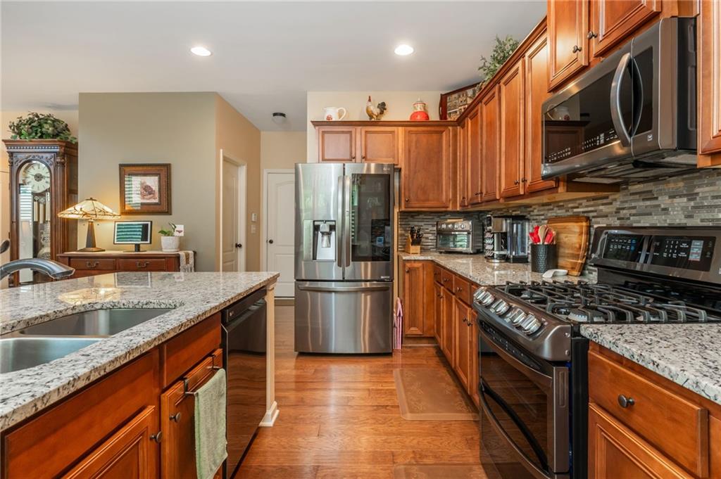 407 Ward Farm Drive Powder Springs, GA 30127 - Photo 24 of 67 a kitchen with stainless steel appliances granite countertop a stove top oven a sink and a refrigerator