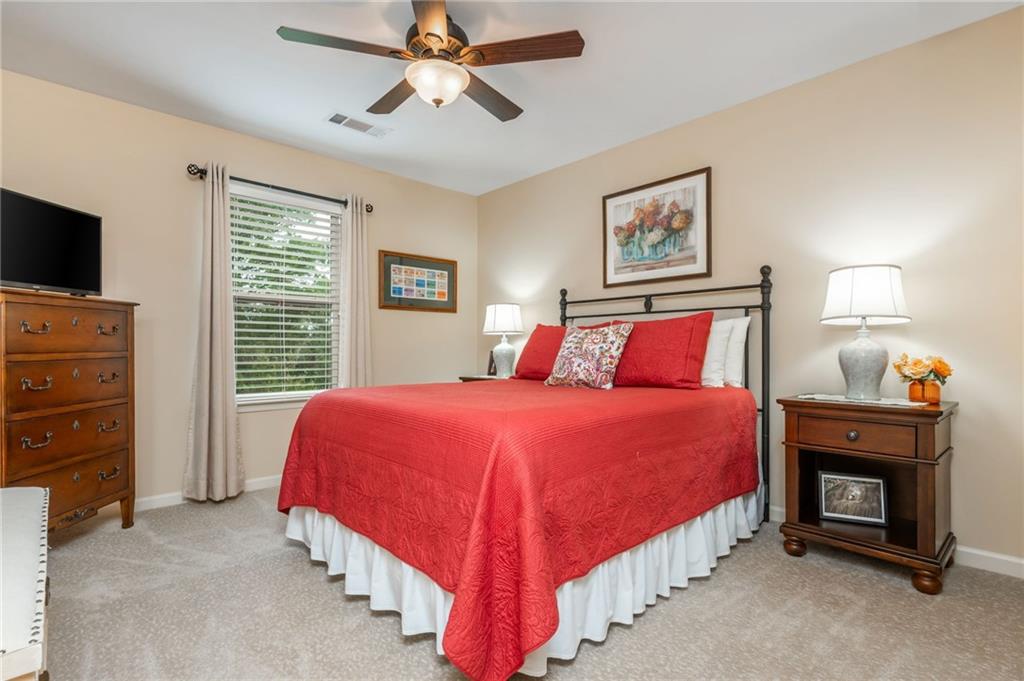 407 Ward Farm Drive Powder Springs, GA 30127 - Photo 45 of 67 a bedroom with a bed and a chandelier