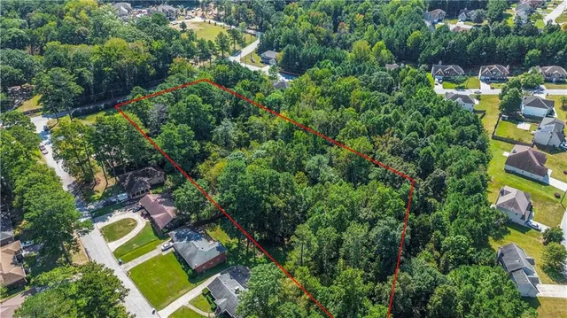 an aerial view of residential house with outdoor space and trees all around