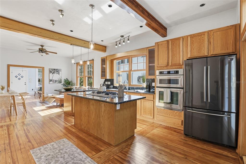 216 Northeast 6th Street Gainesville, FL 32601 - Photo 14 of 36 a kitchen with stainless steel appliances granite countertop a refrigerator a stove and a wooden floors