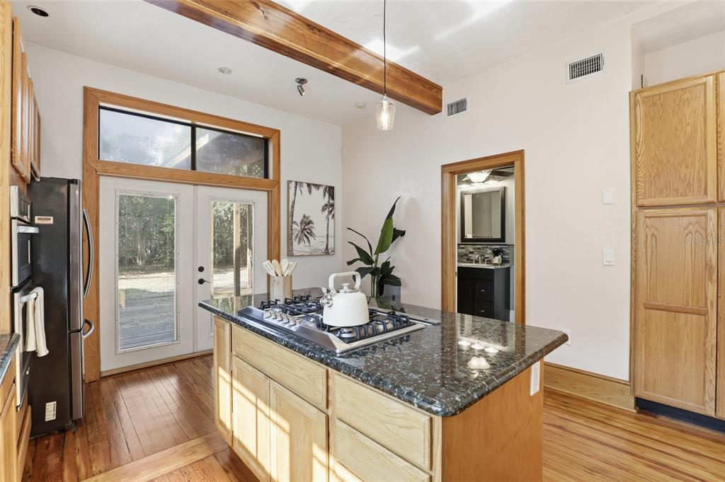 216 Northeast 6th Street Gainesville, FL 32601 - Photo 16 of 36 a kitchen with kitchen island granite countertop a refrigerator a stove and a sink