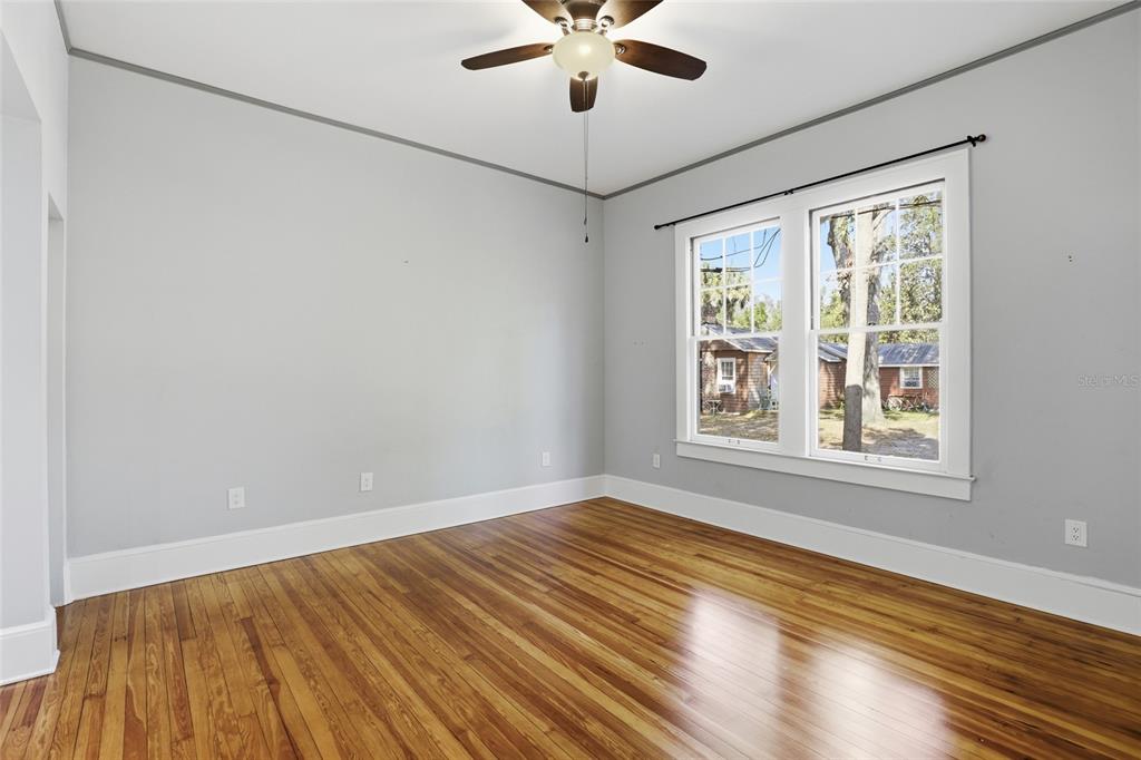 216 Northeast 6th Street Gainesville, FL 32601 - Photo 21 of 36 a view of an empty room with wooden floor and a window