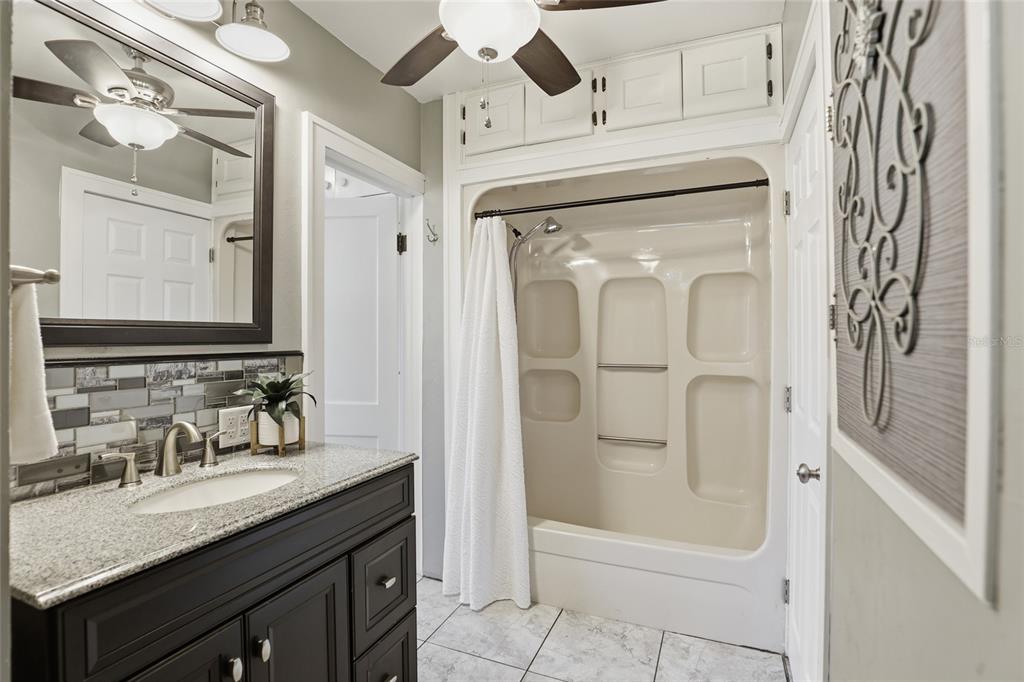 216 Northeast 6th Street Gainesville, FL 32601 - Photo 23 of 36 a bathroom with a granite countertop sink vanity mirror and shower