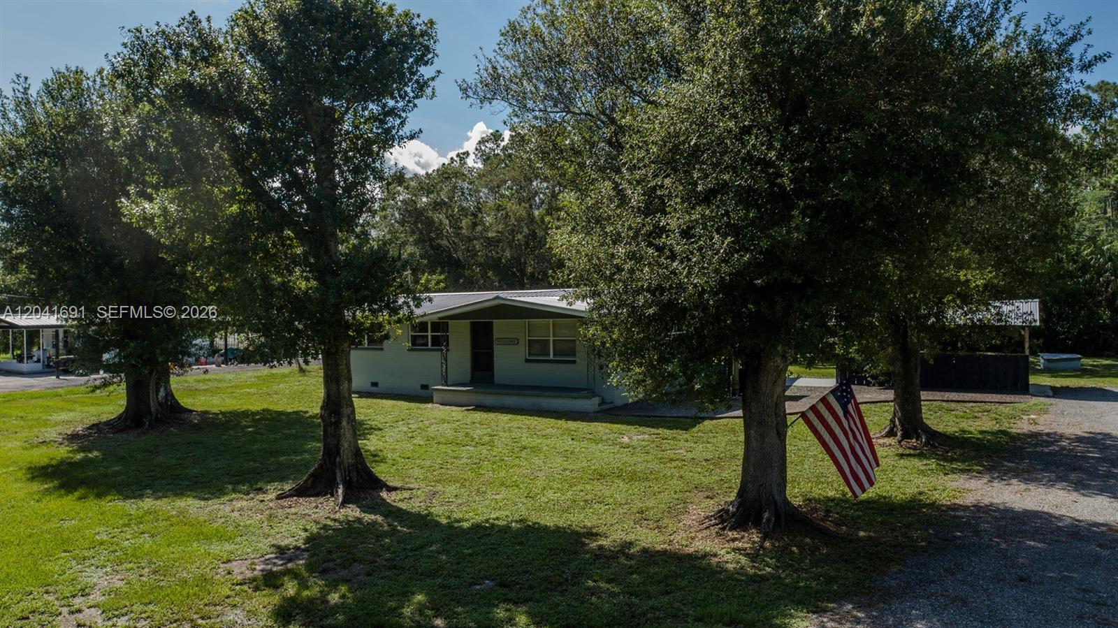 1270 Nobles Road LaBelle, FL 33935 - Photo 1 of 18 a view of a backyard with large trees