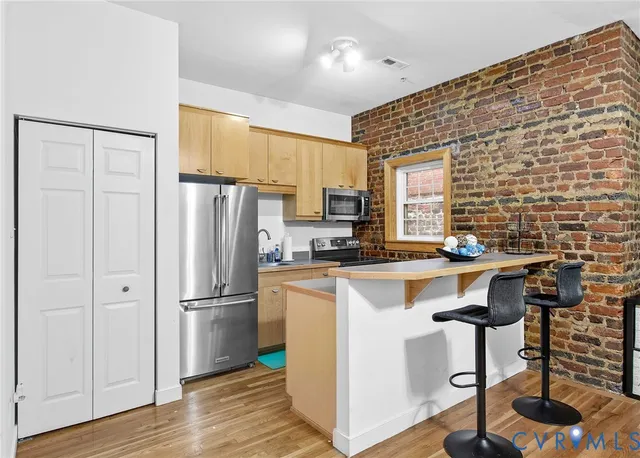 a kitchen with stainless steel appliances granite countertop a sink refrigerator and microwave