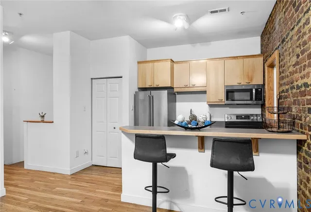 a kitchen with stainless steel appliances a refrigerator sink and microwave