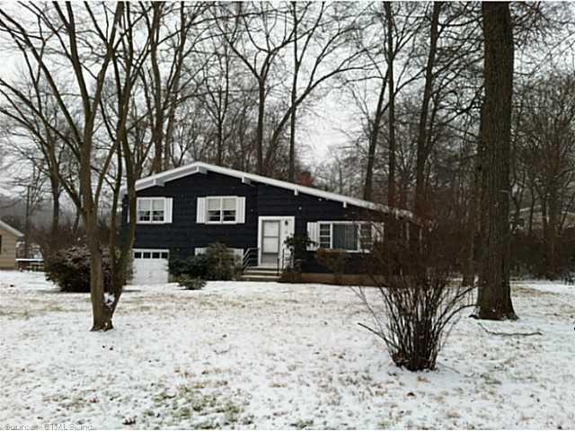 a front view of a house with a yard covered in snow