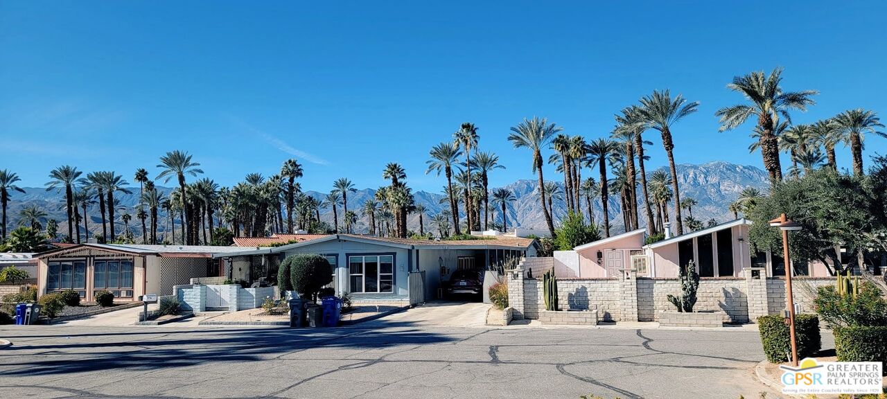 a front view of a house with palm trees