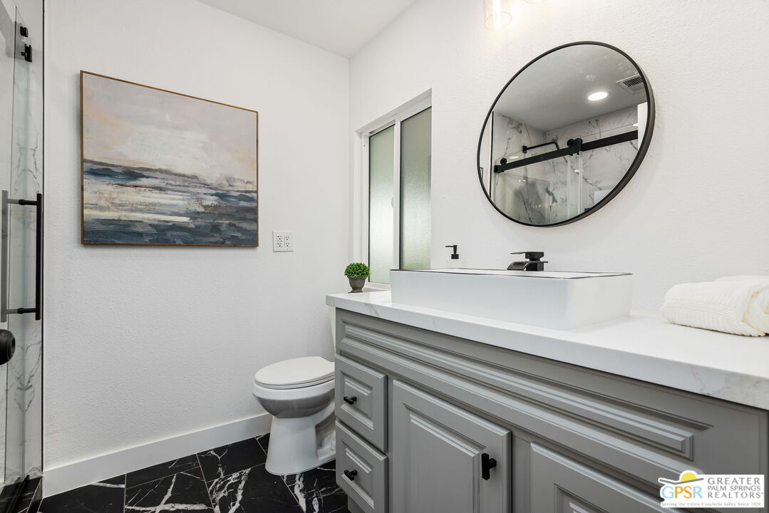 142 Capri Rancho Mirage, CA 92270 - Photo 13 of 26 a bathroom with a toilet a sink and a mirror