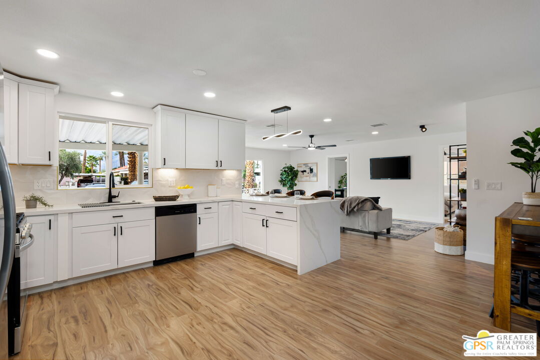 142 Capri Rancho Mirage, CA 92270 - Photo 3 of 26 a kitchen with stainless steel appliances white cabinets sink and wooden floor
