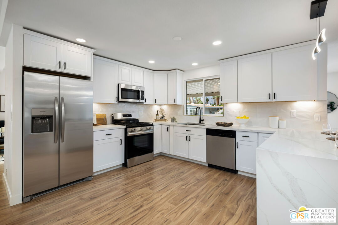 142 Capri Rancho Mirage, CA 92270 - Photo 4 of 26 a kitchen with granite countertop a refrigerator stove top oven and sink