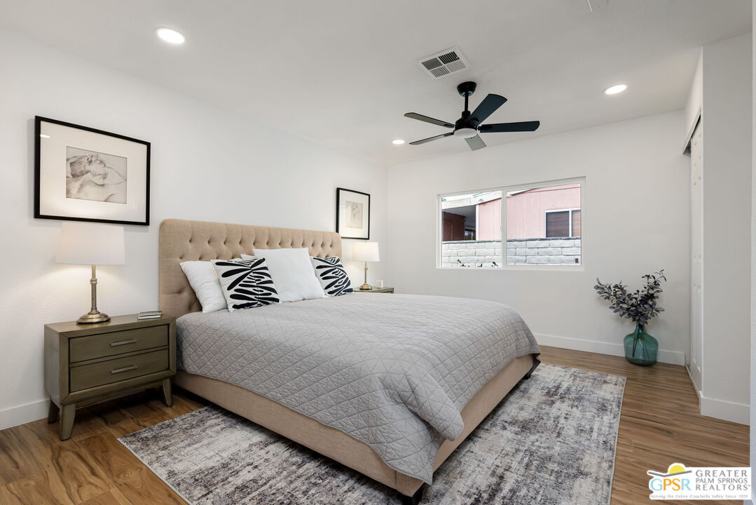 142 Capri Rancho Mirage, CA 92270 - Photo 8 of 26 a bedroom with a bed and wooden floor