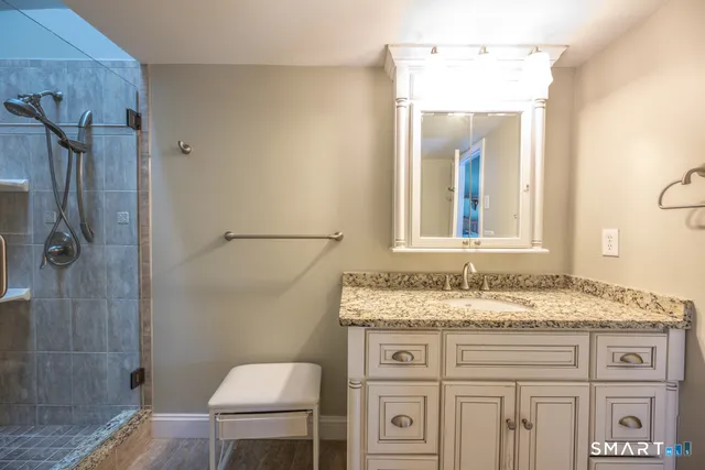 a bathroom with a granite countertop sink vanity and mirror