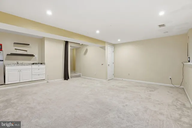 a view of an empty room with a kitchen