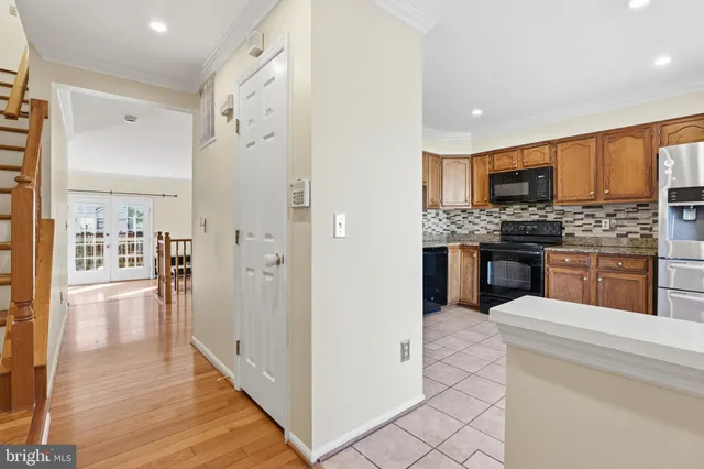 a kitchen with stainless steel appliances kitchen island granite countertop a refrigerator and a stove top oven