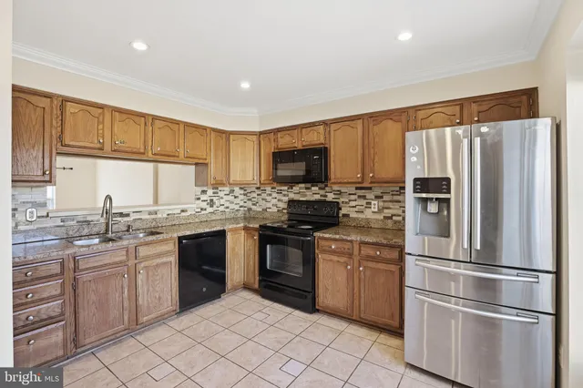 a kitchen with granite countertop stainless steel appliances and wooden cabinets
