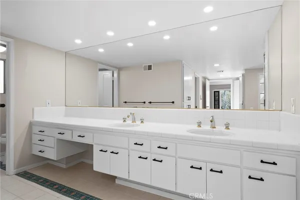 a spacious bathroom with a tub sink shower and mirror