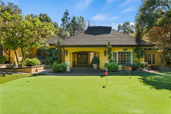 a view of a house with a yard and sitting area