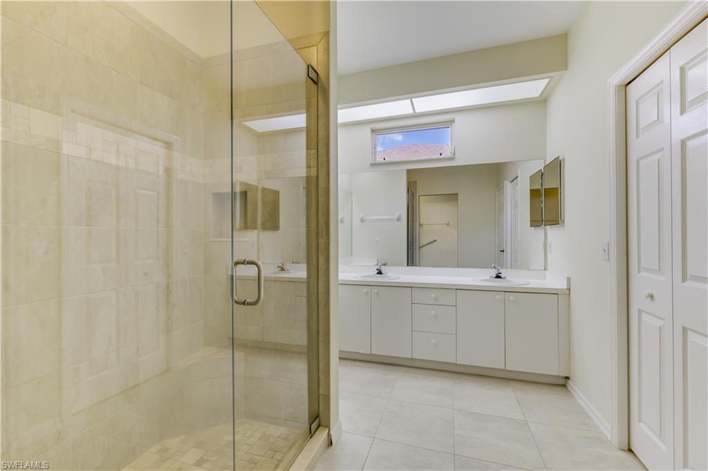 160 Stanhope Circle Naples, FL 34104 - Photo 14 of 17 a bathroom with a shower sink and mirror