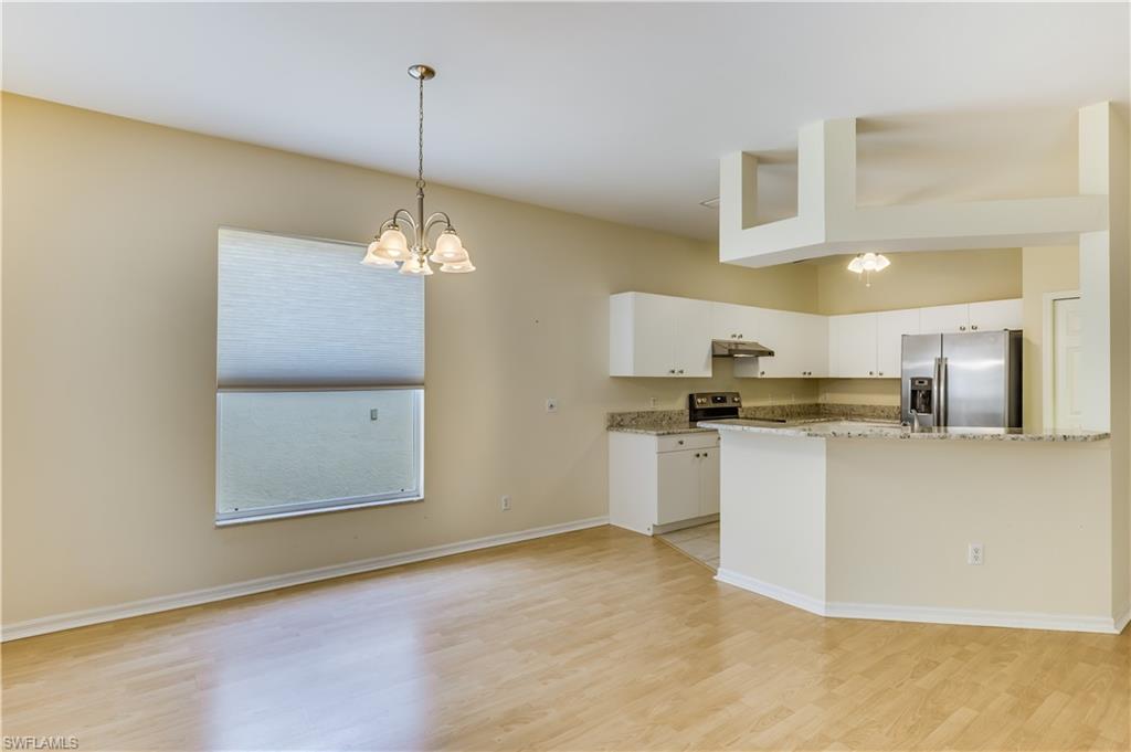160 Stanhope Circle Naples, FL 34104 - Photo 5 of 17 a kitchen with stainless steel appliances granite countertop a sink a window a refrigerator and white cabinets