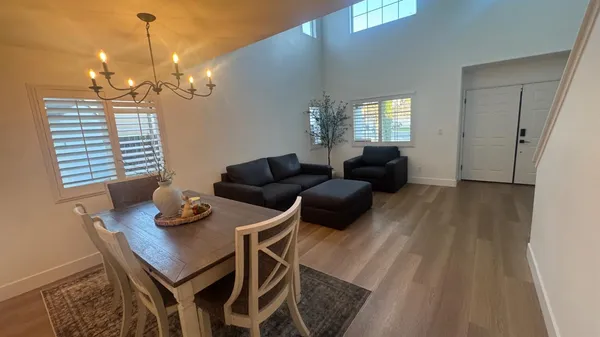 a view of a dining room with furniture and a chandelier