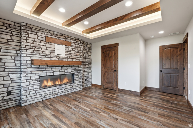 2970 North Mahogany Vly Road Logan, UT 84341 - Photo 31 of 39 Unfurnished living room featuring recessed lighting, dark wood-style flooring, beamed ceiling, and a stone fireplace