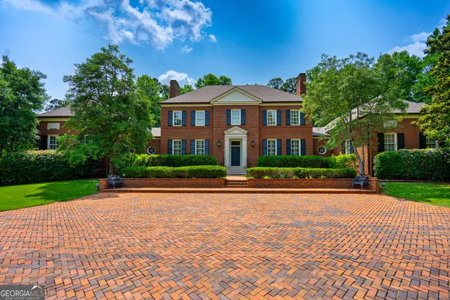 a front view of a house with a yard and potted plants