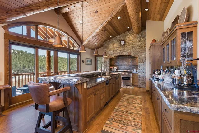 a large kitchen with stainless steel appliances granite countertop a stove and a dining table