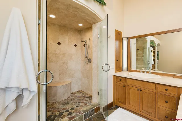 a bathroom with a granite countertop sink a toilet and shower