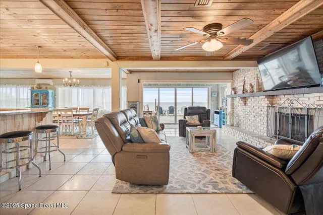 a living room with furniture a fireplace and a floor to ceiling window
