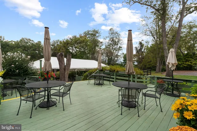 a view of a patio with table and chairs and wooden floor