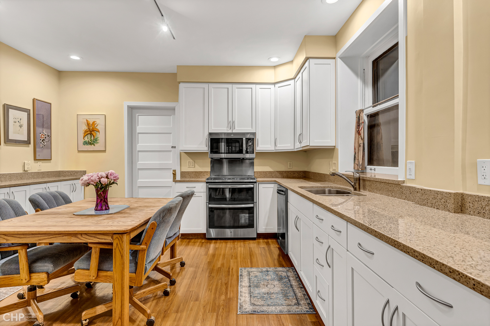 684 West Irving Park Road, Unit E5 Chicago, IL 60613 - Photo 20 of 45 a kitchen with stainless steel appliances granite countertop a stove a sink and a microwave