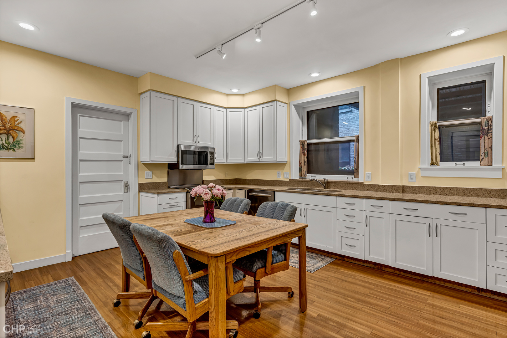 684 West Irving Park Road, Unit E5 Chicago, IL 60613 - Photo 22 of 45 a kitchen with granite countertop a table chairs sink and cabinets