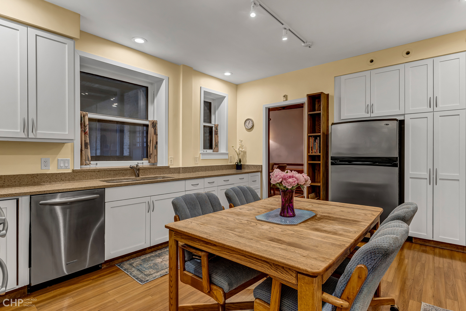 684 West Irving Park Road, Unit E5 Chicago, IL 60613 - Photo 23 of 45 a kitchen with stainless steel appliances granite countertop a table chairs and refrigerator