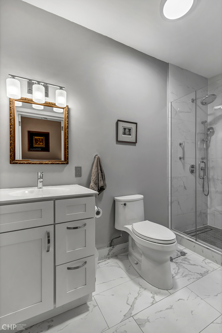 684 West Irving Park Road, Unit E5 Chicago, IL 60613 - Photo 29 of 45 a bathroom with a sink toilet and shower