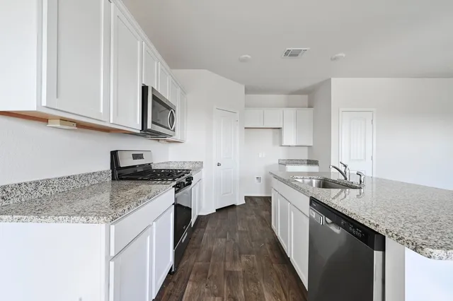 a kitchen with stainless steel appliances granite countertop a sink stove and refrigerator