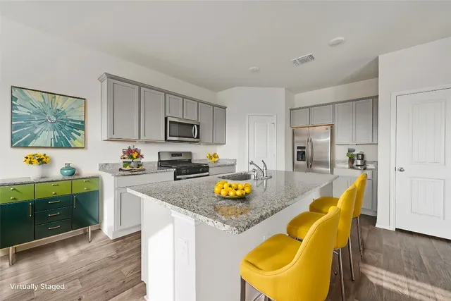 a kitchen with stainless steel appliances granite countertop a refrigerator a stove top oven a sink and dishwasher