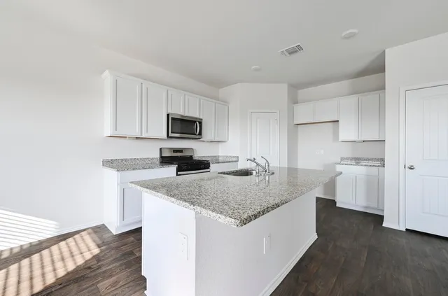 a kitchen with granite countertop a sink stove and refrigerator
