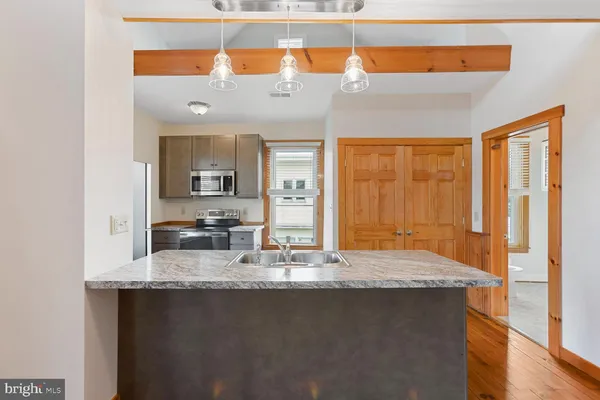 a kitchen with granite countertop a sink a stove and cabinets
