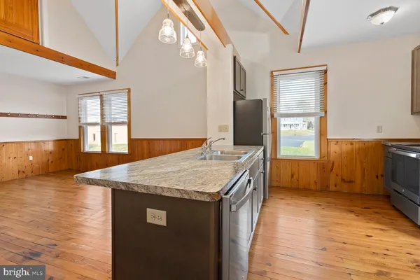 a kitchen with a sink a counter top space and stainless steel appliances