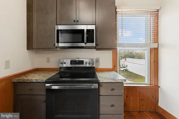 a kitchen with stainless steel appliances granite countertop a stove microwave and sink