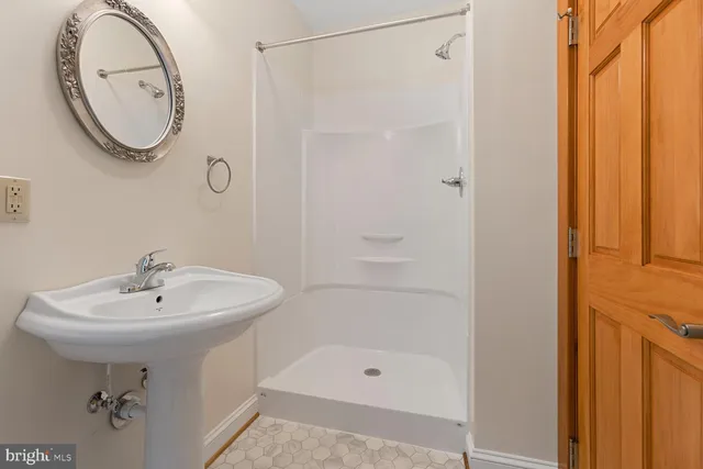 a bathroom with a sink a mirror and a shower