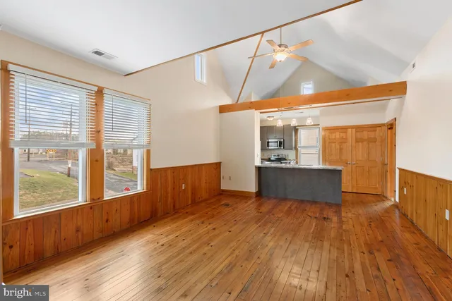 a view of a kitchen with wooden floor and a window