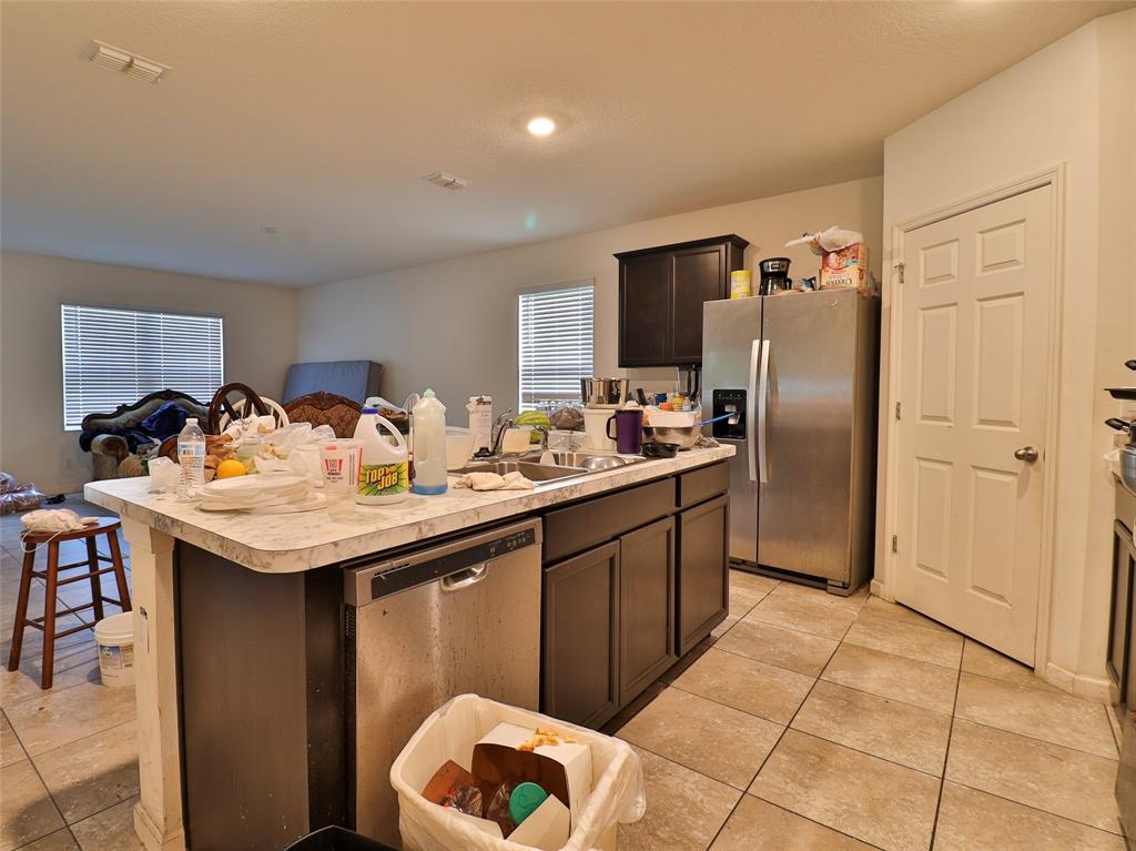1997 Southwest Cycle Street Port St. Lucie, FL 34953 - Photo 23 of 30 a kitchen with stainless steel appliances granite countertop a sink and a refrigerator