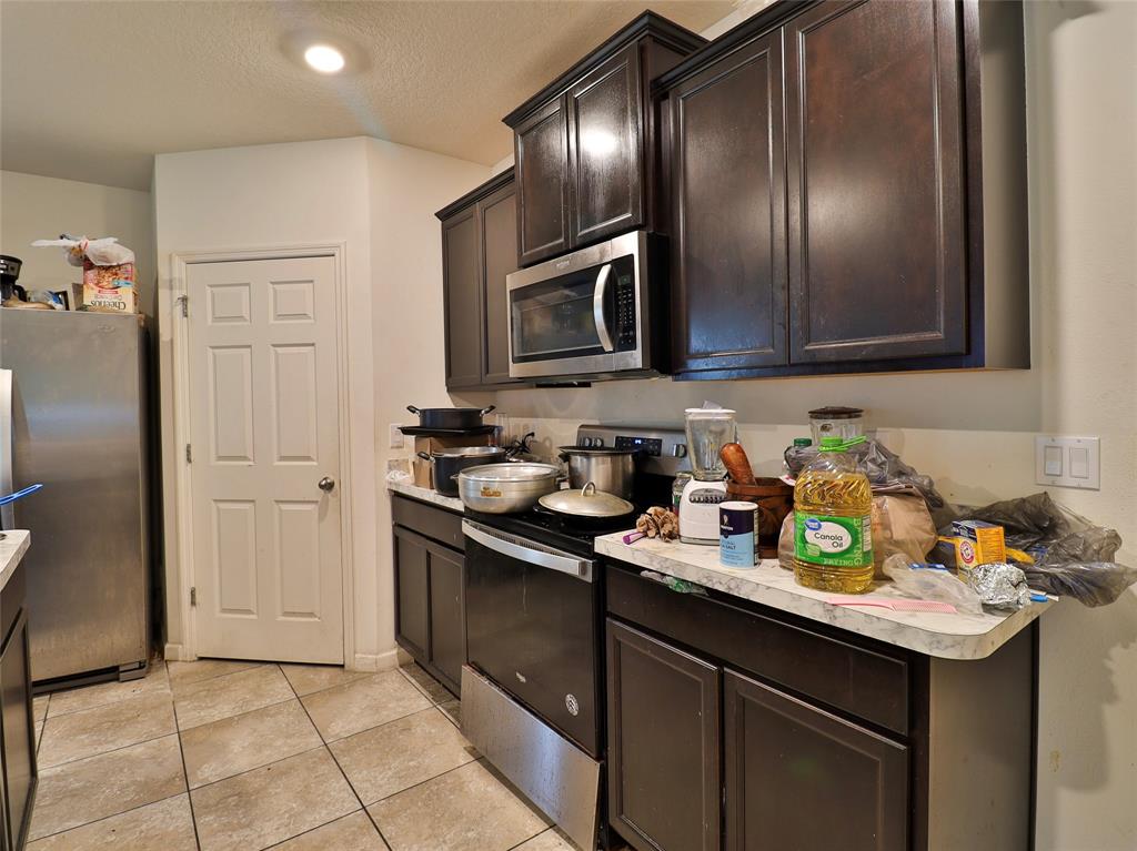 1997 Southwest Cycle Street Port St. Lucie, FL 34953 - Photo 24 of 30 a kitchen with stainless steel appliances granite countertop a sink stove and refrigerator